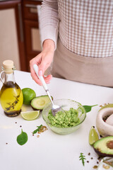 Wall Mural - Toasts preparation - Mashed avocados in a glass bowl