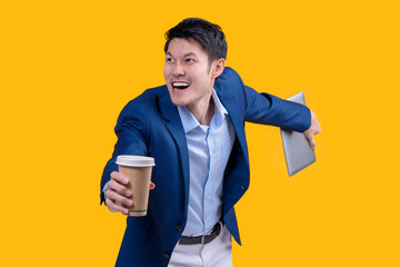 Successful complete Active Happiness asian cheerful exited young businessman running action while holding tablet and coffee mug in isolated on studio yellow colour background