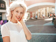 © halayalex - Young beautiful smiling hipster woman in trendy summer dress clothes. Sexy carefree model posing in the street at sunny day. Positive blond female outdoors. Cheerful and happy