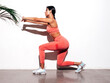 © halayalex - Tanned fitness woman in pink sports clothing. Sexy young beautiful model with perfect body.Female isolated on white background in studio. Stretching out before training. Near wall. Making lunges