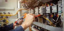 Electrical Engineer Using Measuring Equipment To Checking Electric Current Voltage At Circuit Breaker And Cable Wiring System , Electrical Service Concept .