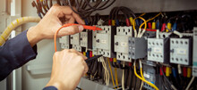 Electrical Engineer Using Measuring Equipment To Checking Electric Current Voltage At Circuit Breaker And Cable Wiring System , Electrical Service Concept .