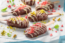Delicious and homemade popsicles with chocolate topping and pistachios.
