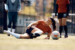 © Drazen - Happy athletic woman laughing after slipping on the grass during soccer training.