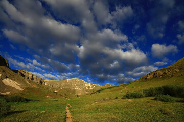 Spring mountain landscape panorama with forest and sun.