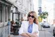 © bisonov - Stylish beautiful business woman in a white jacket on the street