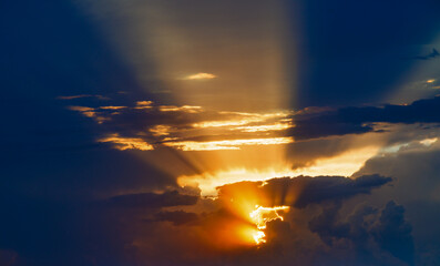 Wall Mural - cloudy sunset sky with yellow sun rays without horizon, captured with 100mm lens