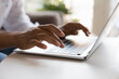 © fizkes - Young laptop user woman using computer, typing on keyboard. Female hands close up. Homeowner in casual, freelancer, writer working at table, sitting on home couch, chatting. Cropped shot