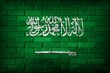 Saudi Arabia flag painted on a brick wall.