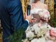 The bride and groom close-up. The groom says an oath with a microphone, and the bride stands opposite and holds a bouquet.