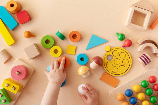 toddler activity for motor and sensory development. baby hands with colorful wooden toys on table fr