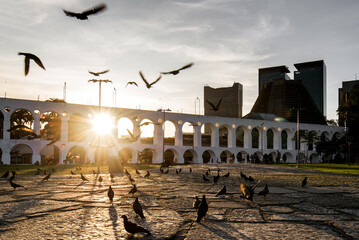 Fototapete - Sun Shines Through Lapa Arches in Rio de Janeiro With Pigeons Flying in Front of It