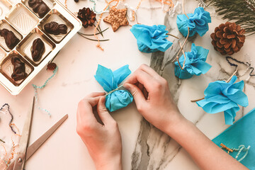 Teenage girl making handmade Christmas gift with chocolate sweets for New Year, Christmas holidays. Do it yourself concept, creativity, step by step process.