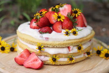 Tiered Layered Cake With Yellow Wildflowers And Strawberries With White Frosting Icing On Wood Board Summer Cake Rustic Minimalist - Naked Cake
