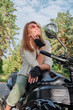 © perfectlab - Middle age woman biker drives a motorcycle on a forest road, travels alone