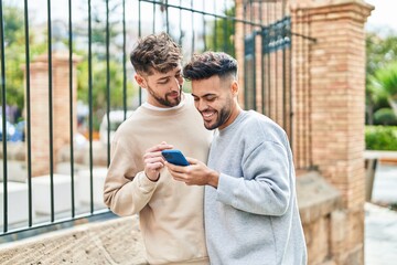 Young couple using smartphone standing together at street