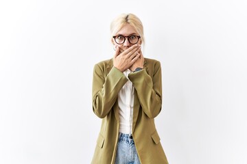 Canvas Print - Beautiful caucasian business woman standing over isolated background shocked covering mouth with hands for mistake. secret concept.