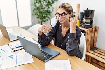 Poster - Young blonde woman working at the office wearing safety mask surprised with an idea or question pointing finger with happy face, number one