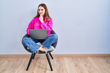 Sticker - Young hispanic girl working using computer laptop with hand on chin thinking about question, pensive expression. smiling and thoughtful face. doubt concept.