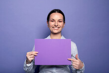Young Business Woman Holding Purple Blank Advertising Board Standing On Lilac Background In Studio