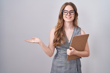 Poster - Caucasian woman wearing glasses and business clothes smiling cheerful presenting and pointing with palm of hand looking at the camera.