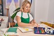 © Krakenimages.com - Young blonde woman artist drawing on notebook at art studio