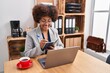 © Krakenimages.com - African american woman business worker using laptop writing on notebook at office
