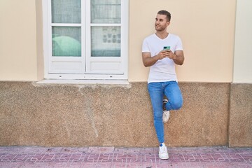 Sticker - Young caucasian man smiling confident using smartphone at street