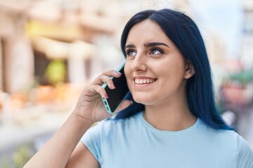 Wall Mural - Young caucasian woman smiling confident talking on the smartphone at street