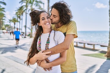 Wall Mural - Man and woman couple kissing and hugging each other at seaside