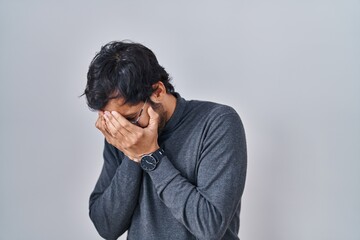 Sticker - Handsome latin man standing over isolated background with sad expression covering face with hands while crying. depression concept.