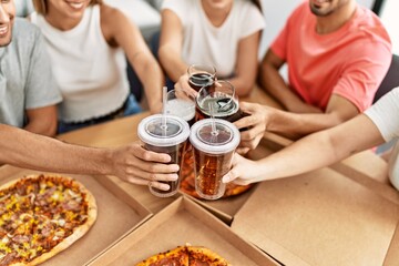 Sticker - Group of young friends smiling happy eating italian pizza and toasting with cola beverage at home.