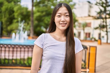 Canvas Print - Young chinese girl smiling happy standing at the city.