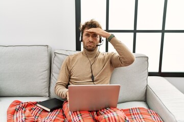 Poster - Young handsome man with beard wearing operator headset working from home worried and stressed about a problem with hand on forehead, nervous and anxious for crisis