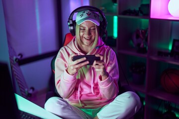 Poster - Young blonde woman streamer smiling confident playing video game at gaming room