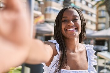 Sticker - Young african american girl smiling happy make selfie by the camera at the promenade