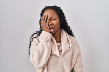 Wall Mural - African woman standing over white background yawning tired covering half face, eye and mouth with hand. face hurts in pain.