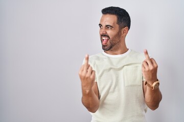 Poster - Hispanic man with beard standing over isolated background showing middle finger doing fuck you bad expression, provocation and rude attitude. screaming excited