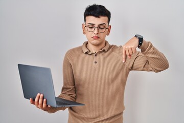 Canvas Print - Non binary person using computer laptop pointing down looking sad and upset, indicating direction with fingers, unhappy and depressed.