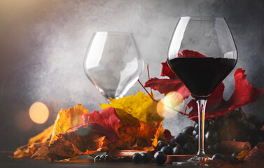 Wall Mural - Red wine Cabernet Franc in  glass on  dark background with autumn grape leaves