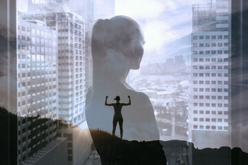 Wall Mural - Woman standing on a mountain top achieving her goals. Strong young determined woman in the city. 