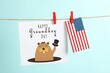 Leinwandbild Motiv Happy Groundhog Day greeting card and American flag hanging on turquoise background