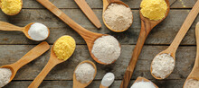 Spoons With Many Kinds Of Flour On Wooden Background