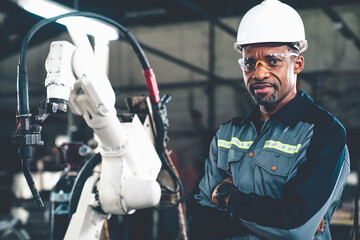 Poster - African American factory worker working with adept robotic arm in a workshop . Industry robot programming software for automated manufacturing technology .