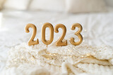 Fototapeta Mapy - Happy New Years 2023. Christmas background with 2023 candles and white knit sweater. Christmas holiday celebration. New Year concept.