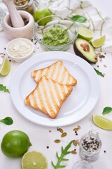 Wall Mural - Toasts preparation - grilled toast bread and mashed avocado