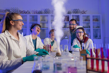 excited science students with teacher doing chemical experiment in the laboratory at university.