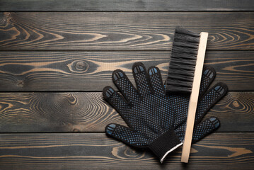 Wall Mural - Dust brush and work gloves on the wooden workbench flat lay background with copy space.