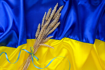 Poster - Fabric wave flag of Ukraine with wheat spikes. Blue and yellow bright colors. Curved texture background