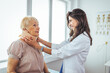 © Dragana Gordic - Female doctor putting neck orthopaedic collar on adult injured woman. Doctor talking to a senior patient with cervical collar at the hospital.